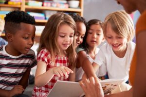 group of kids at school looking at a book