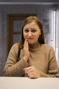 woman with a toothache holding her face debating if she needs an El Paso root canal